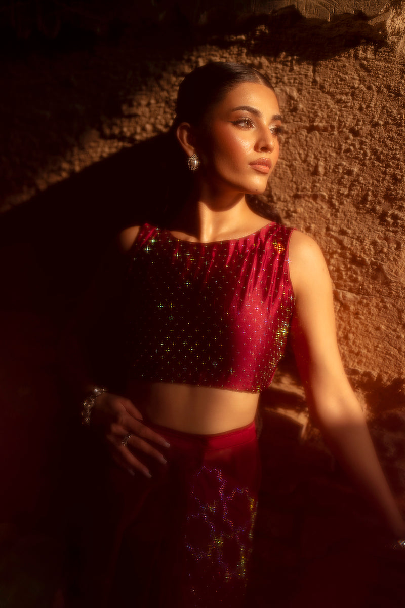 Woman in a red traditional outfit against a textured wall